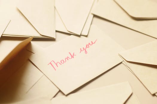 A thank you card surrounded by beige envelopes, conveying gratitude and appreciation.
