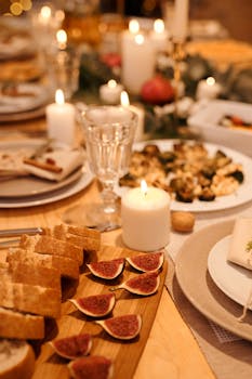 Warm and inviting Christmas dinner setup with candles, bread, figs, and a festive atmosphere.