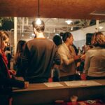 A lively indoor social gathering with people interacting warmly under cozy lighting.