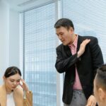 Diverse business team engaged in a serious discussion during a meeting in a modern office setting.