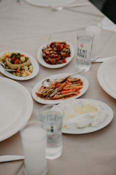 Elegant display of assorted Turkish meze dishes with Yeni Raki in a restaurant setting.