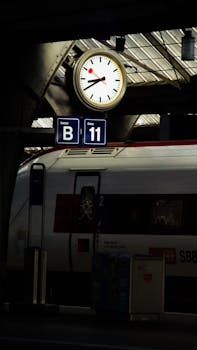 Nighttime view of Zürich railway station platform, featuring a clock and SBB train with seating information.