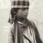 Sepia-toned portrait of a boy in traditional Indian clothing, wearing a headscarf in Nagur, Maharashtra.