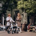 Two adults with mobility aids enjoying a day outdoors in Amsterdam.